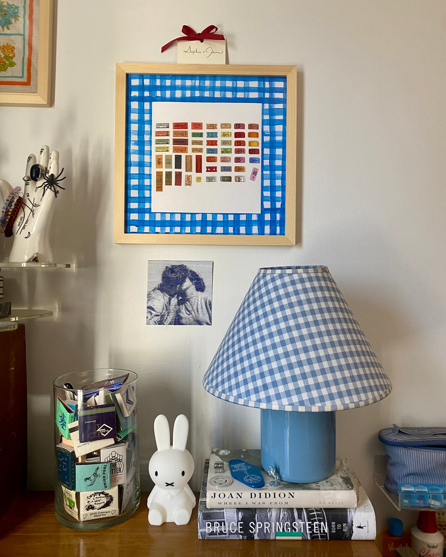 ticket print framed with a blue gingham mat mathcing the blue gingham lampshade below